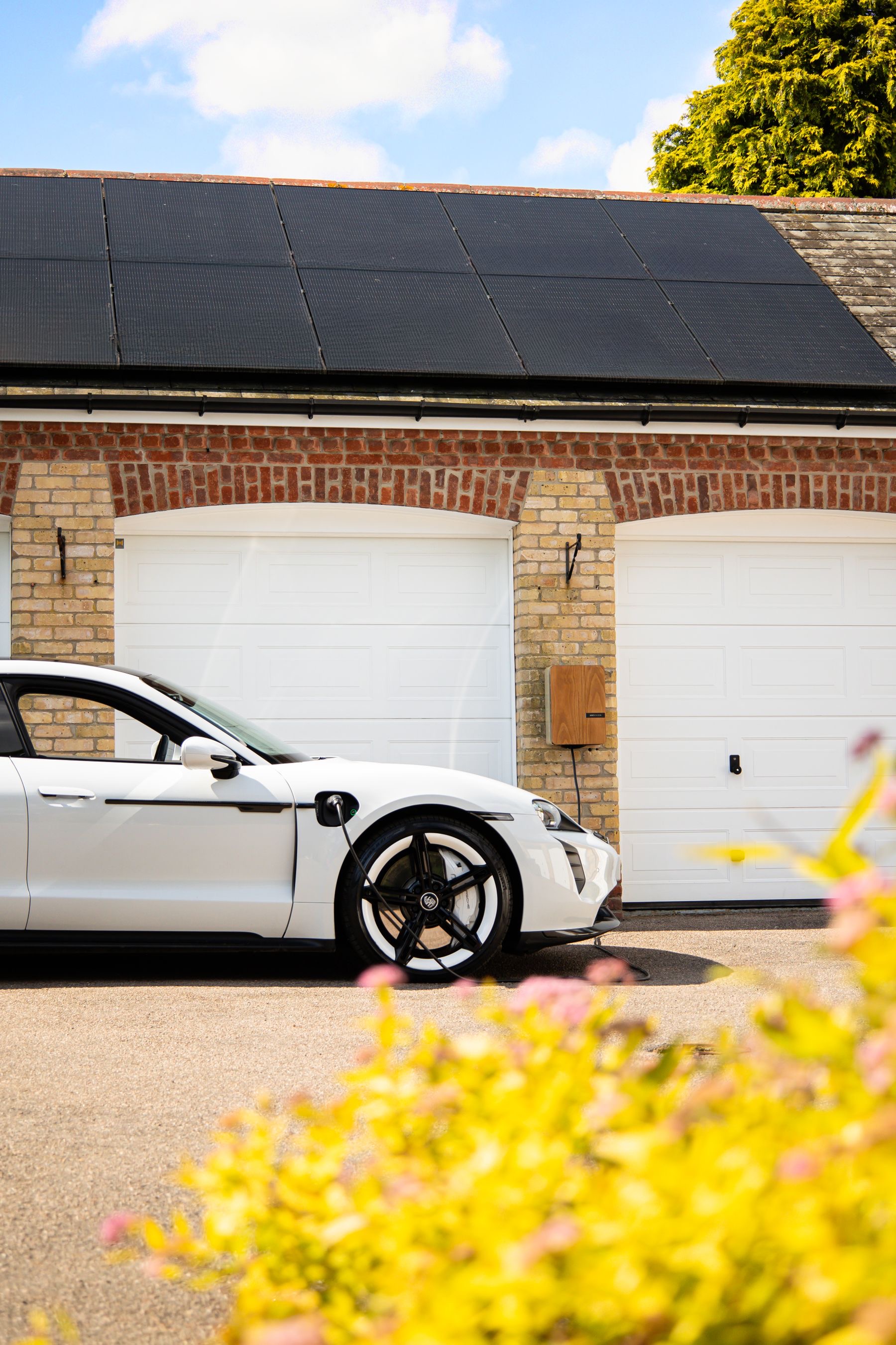Recharge solaire : Une voiture électrique rechargée sous un toit photovoltaïque